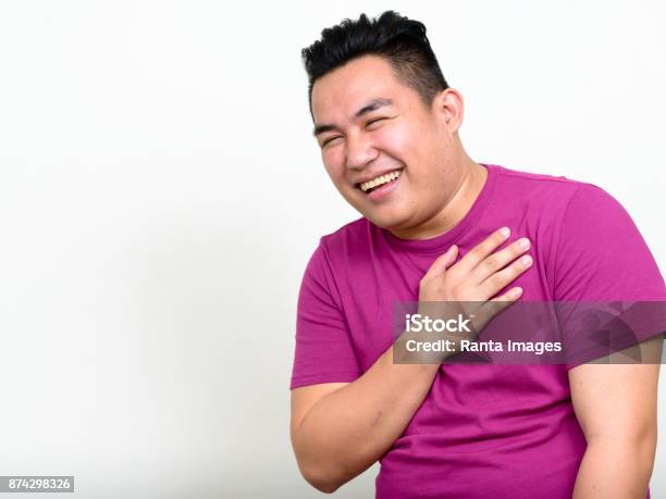 Young Handsome Asian Man Wearing Purple Shirt Against White Background - Fotografias de stock e mais imagens de Adulto