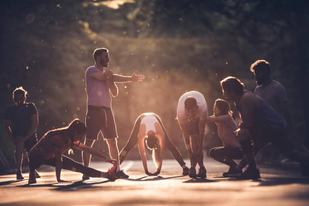 istock Group of athletes preparing for marathon race while warming up on the road at sunset. 874298500