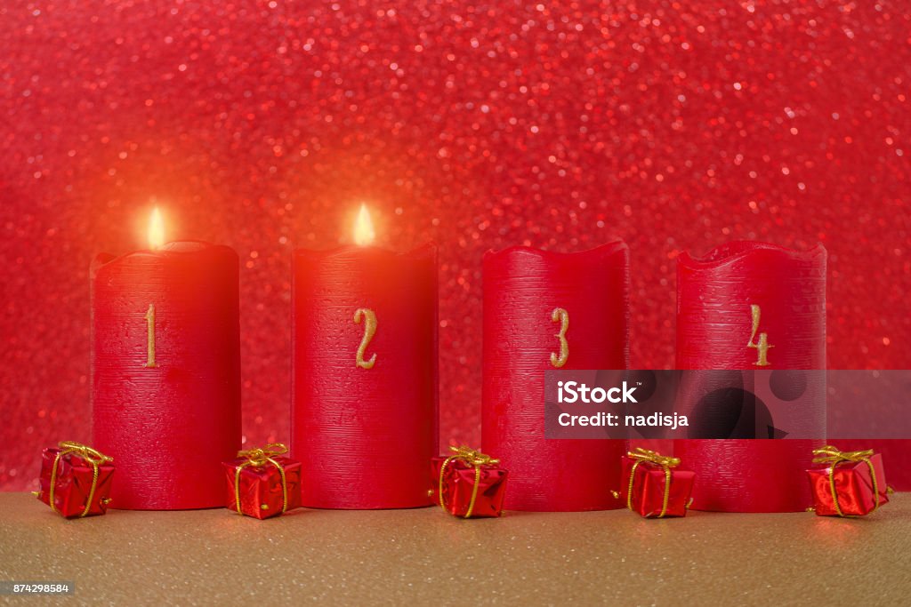 traditionelles Advents-Kerzen mit Zahlen und Geschenke auf rotem Grund - Lizenzfrei Advent Stock-Foto