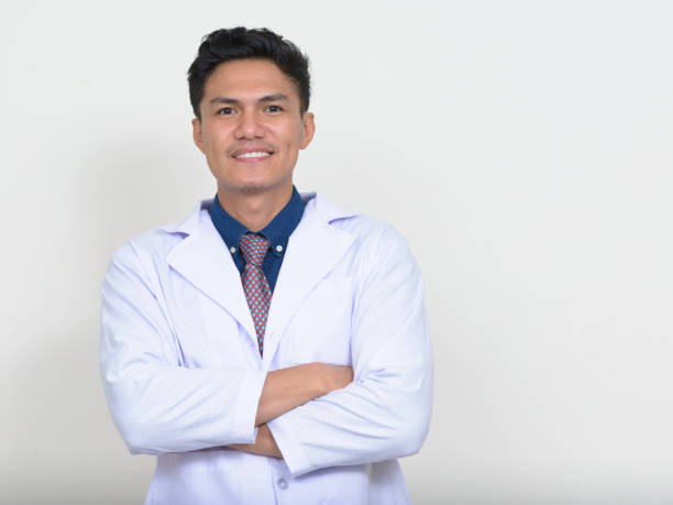 istock Young Asian man doctor against white background 874298626