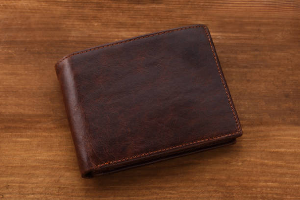 istock Brown wallet on wooden background. Closeup 874301338