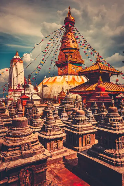 The famous Buddhist stupa at Boudanath in Kathmandu valley, Nepal. Was built in the 14th century. Blue cloudy sky in the background. Travel, holiday. Vintage retro toning filter orange color