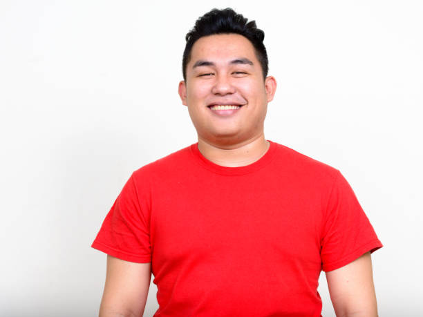 istock Young handsome Asian man wearing red shirt against white background 874305836