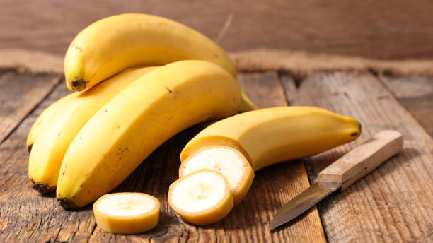 plátano en un fondo de madera - plátano fruta tropical fotos fotografías e imágenes de stock