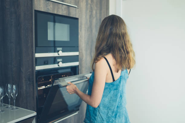 istock Young woman opening the oven 874309550