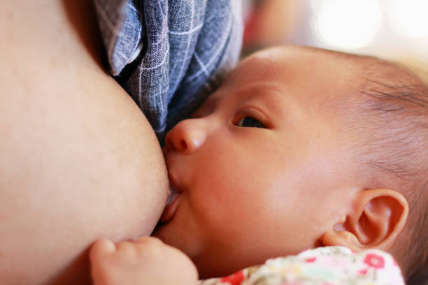 mother is breastfeeding her newborn baby.