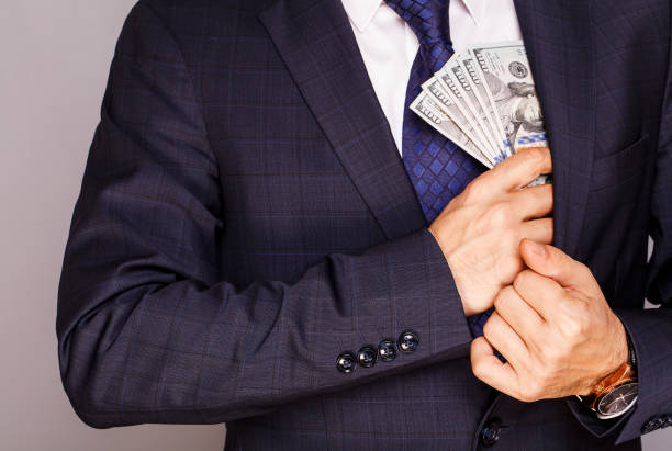 istock Businessman putting money in suit jacket pocket 874316744
