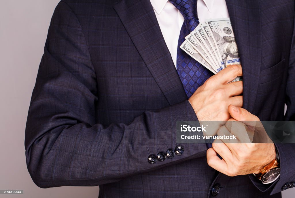 Businessman putting money in suit jacket pocket Currency Stock Photo
