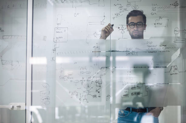 istock Young engineer drawing business ideas on a glass in the office. 874319140