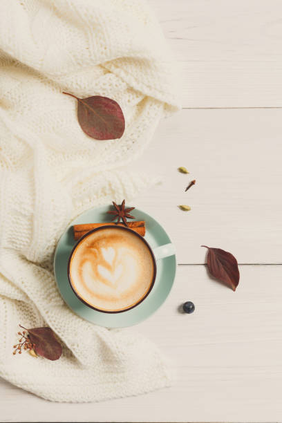 istock Autumn cappuccino coffee cup on white wood background 874320460