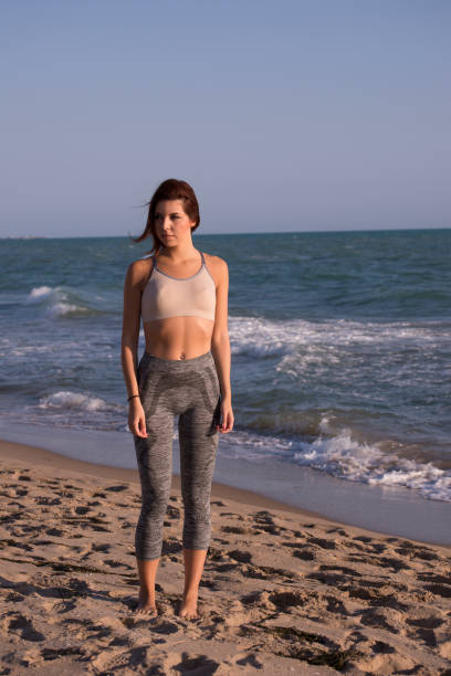 istock Young woman training  on the sea 874323818