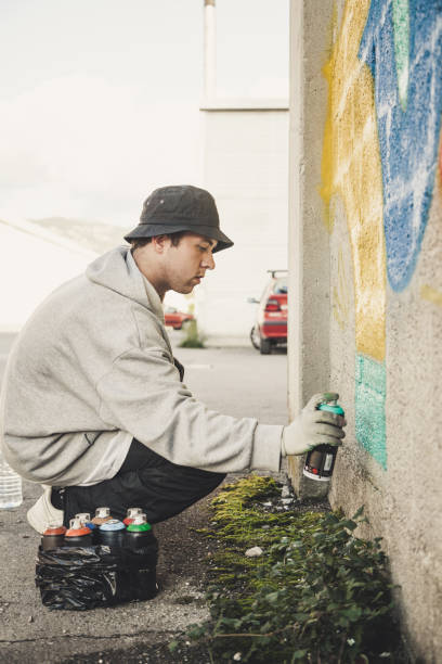 istock Graffiti Artist Spraying on the Wall 874327846