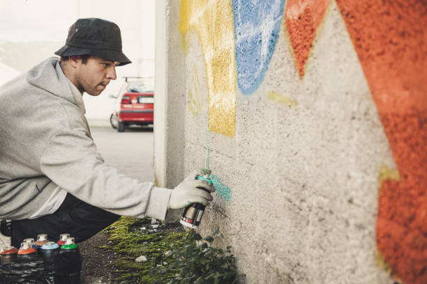 istock Graffiti Artist Spraying on the Wall 874327852