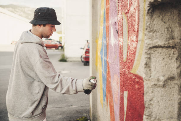 istock Graffiti Artist Spraying on the Wall 874327854