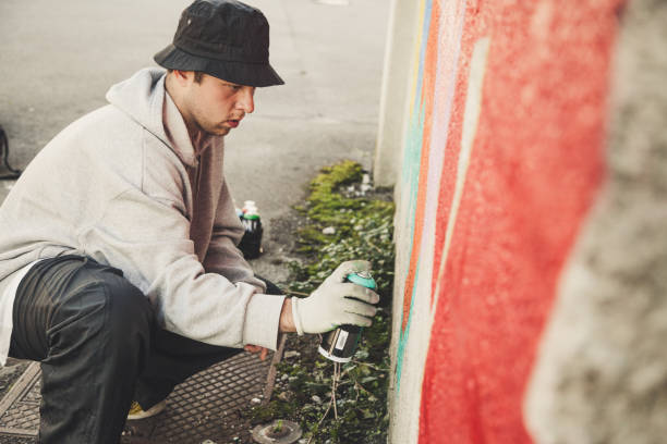istock Graffiti Artist Spraying on the Wall 874327862