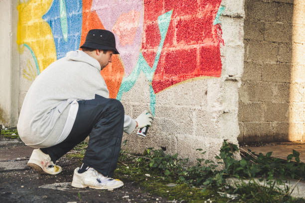 istock Graffiti Artist Spraying on the Wall 874327868