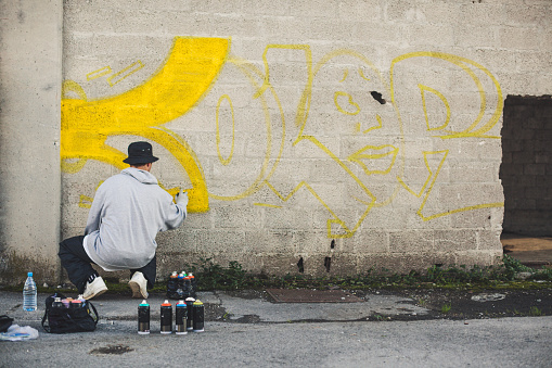 Melbourne, Australia - Sep 9, 2015: Street artist creating graffiti at Hosier Lane in Melbourne, Australia. Hosier Lane is a laneway in CBD of Melbourne, It is a popular landmark in Melbourne due to its graffitti covered walls and urban art.