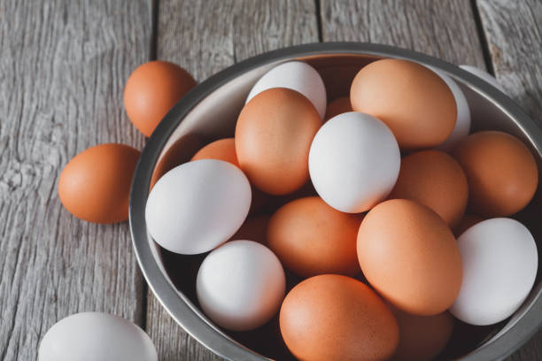 istock Fresh brown eggs in bowl on wood background 874332048