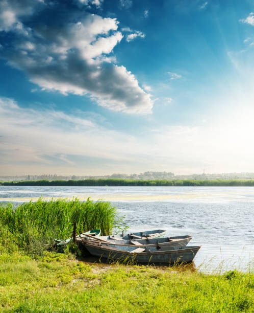 boats on river in sunset and blue sky with clouds