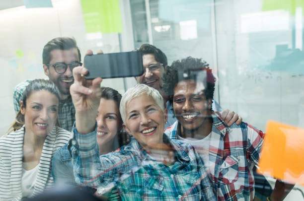 istock Cheerful start up team having fun while taking a selfie in the office. 874342500