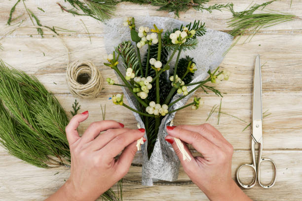 istock woman arranging a bunch of mistletoe 874343572