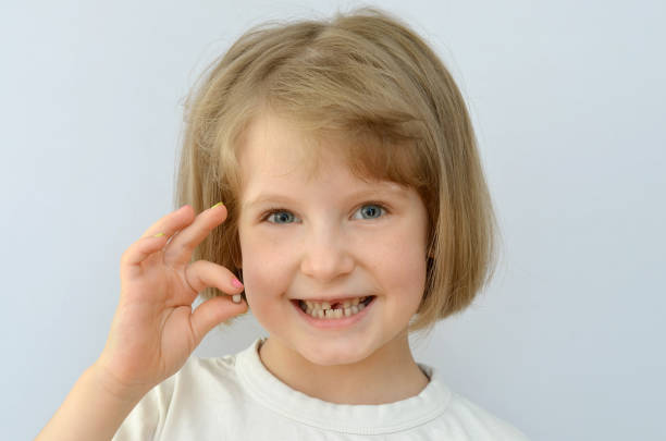 istock child kid shows the fallen baby tooth. 874343914