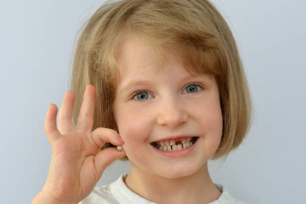 istock child kid shows the fallen baby tooth. 874343920