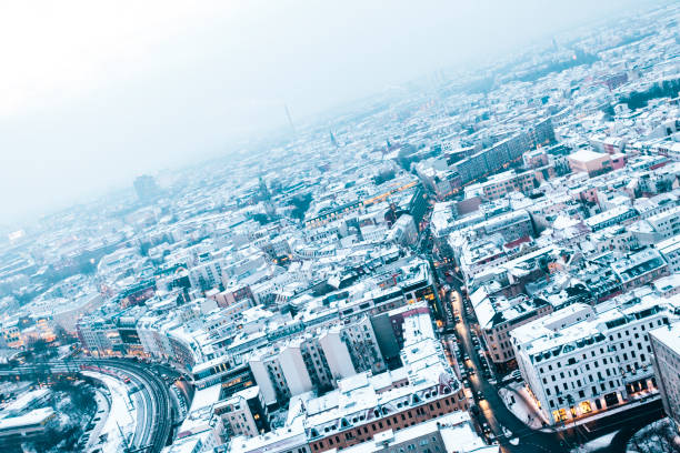 istock Aerial view of snow covered rooftops at dusk, Berlin, Germany 874345734