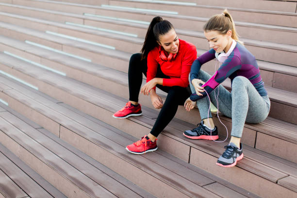 istock Two young woman resting after running 874347092