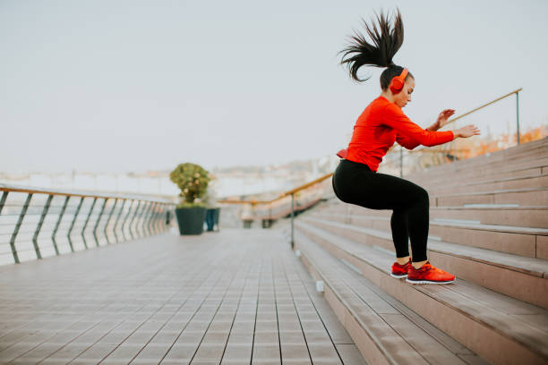 istock Young woman exercising jumping outside 874347290