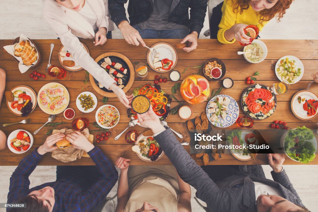 Las personas comen comidas saludables en la mesa de la cena se sirven - Foto de stock de Mesa de comedor libre de derechos