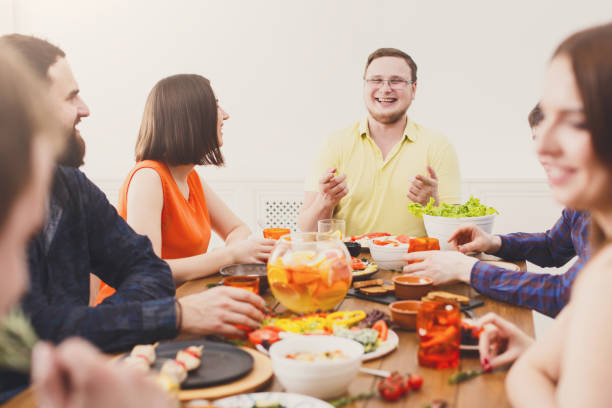 istock Group of happy people at festive table dinner party 874349428