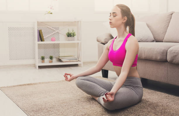istock Woman training yoga in lotus pose, closeup 874352784