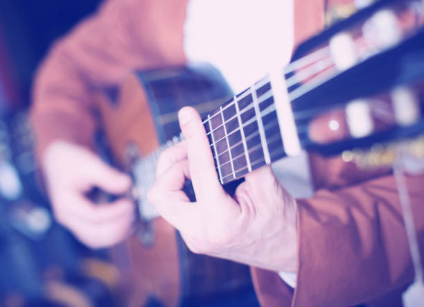 istock man in jacket playing an acoustic guitar 874356064