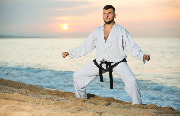 istock Brunette male doing karate at ocean quay 874363822