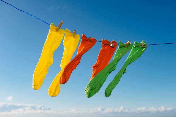 istock Vibrant coloured socks on a washing line against a blue sky. 874369196