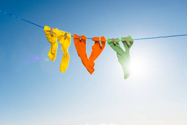 istock Vibrant coloured socks on a washing line against a blue sky. 874369198