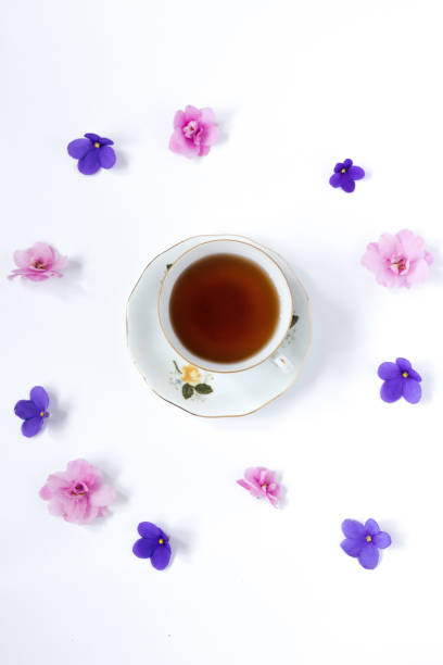 istock Glass cup of herbal tea with flower. white table. Flat lay . 874372464