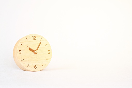 Business, savings time, deadline or delay concept : wooden alarm clock on white background