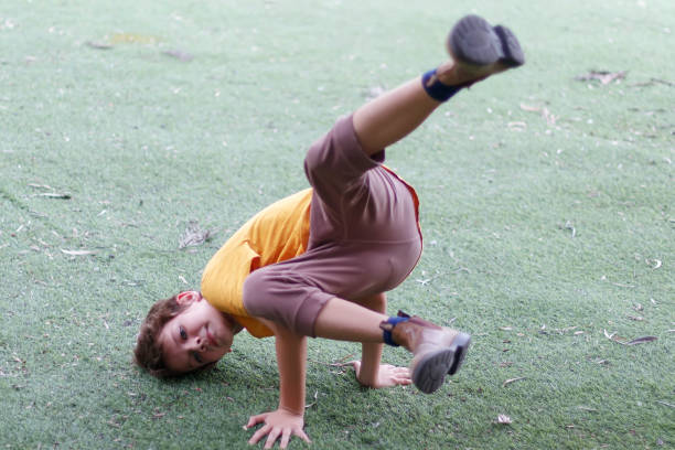 Smiling urban dancer in the park a sunny day. Equilibrium in one arm, and big smile. Arab young man.