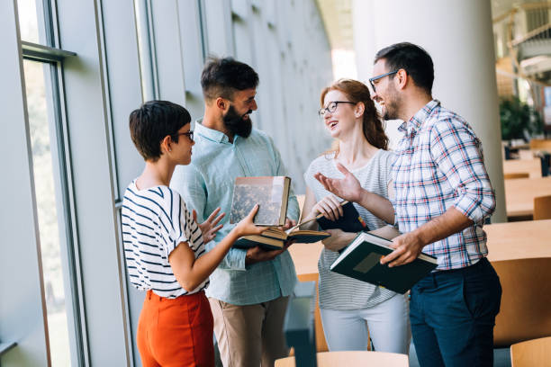 istock Group of students discussing in university library 874384522