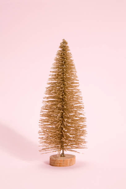 istock golden christmas tree pink background 874387836
