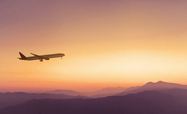 夕焼け空に飛行機旅行 - airplane flying commercial airplane air vehicle ストックフォトと画像