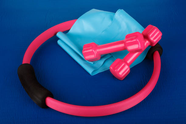istock Pilates Circle, Dumbbell, Band on Blue Yoga Mat 874388182