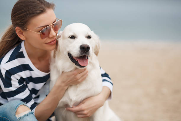 istock Young woman with a dog on a deserted beach 874388228
