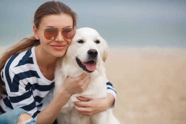 istock Young woman with a dog on a deserted beach 874388236