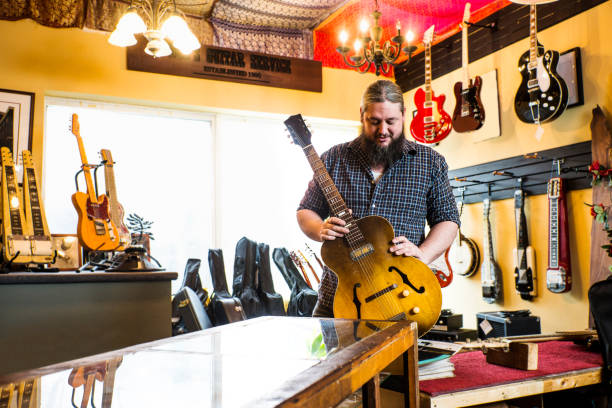 luthier en su tienda de reparación de guitarras - fabricante de instrumentos fotografías e imágenes de stock