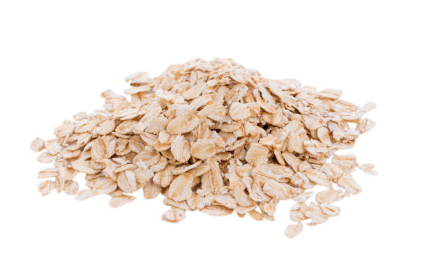 istock Oat flakes pile on white background 874394416