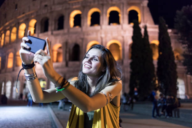 istock Smiling young woman taking selfie in Rome 874395700