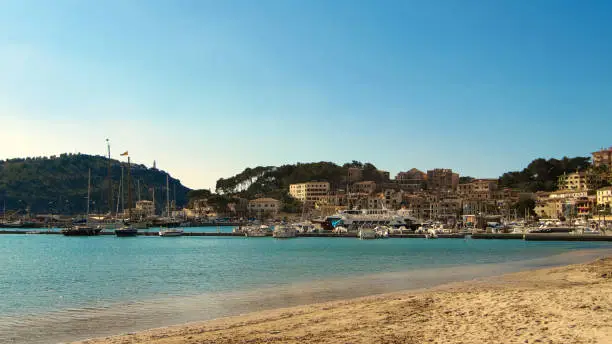 Colorful beach and bay in clear blue water. Puerto de Soller llorca island in balearic islands, Spain.